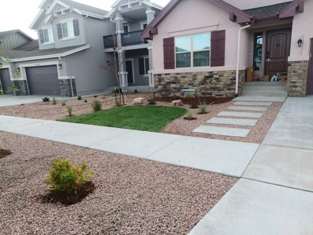 Front yard transformation from unfinished dirt to polished xeriscape with plants and rock

