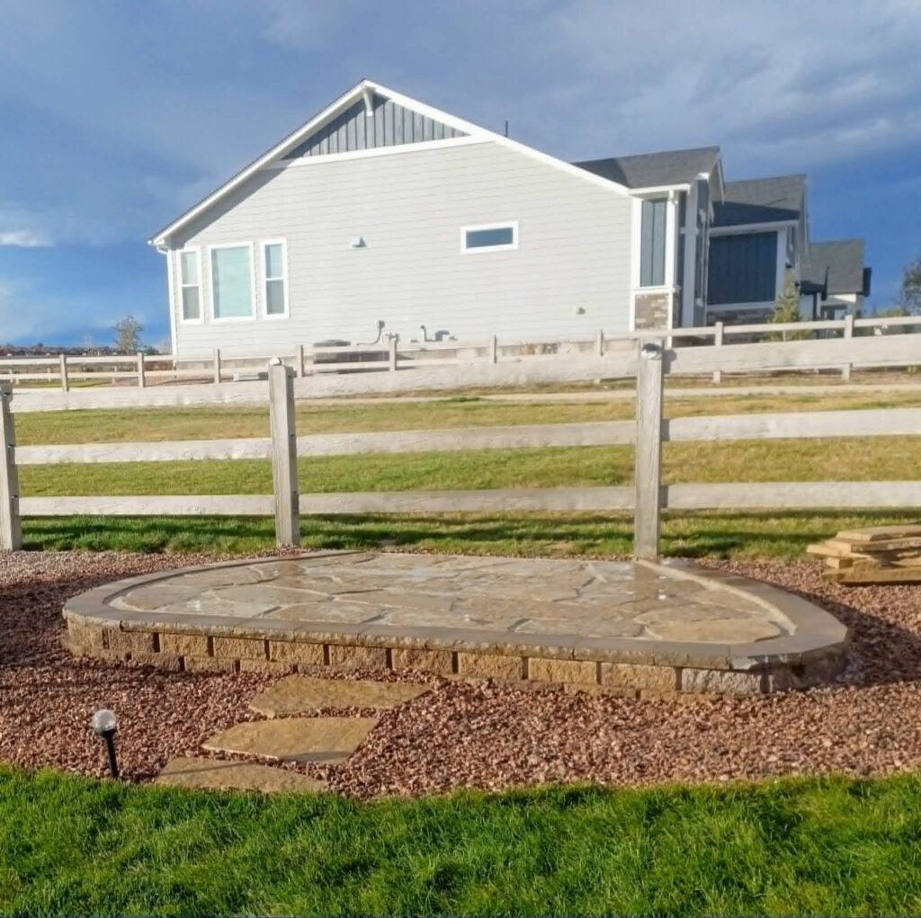 Tiered natural stone retaining wall creating level patio space

