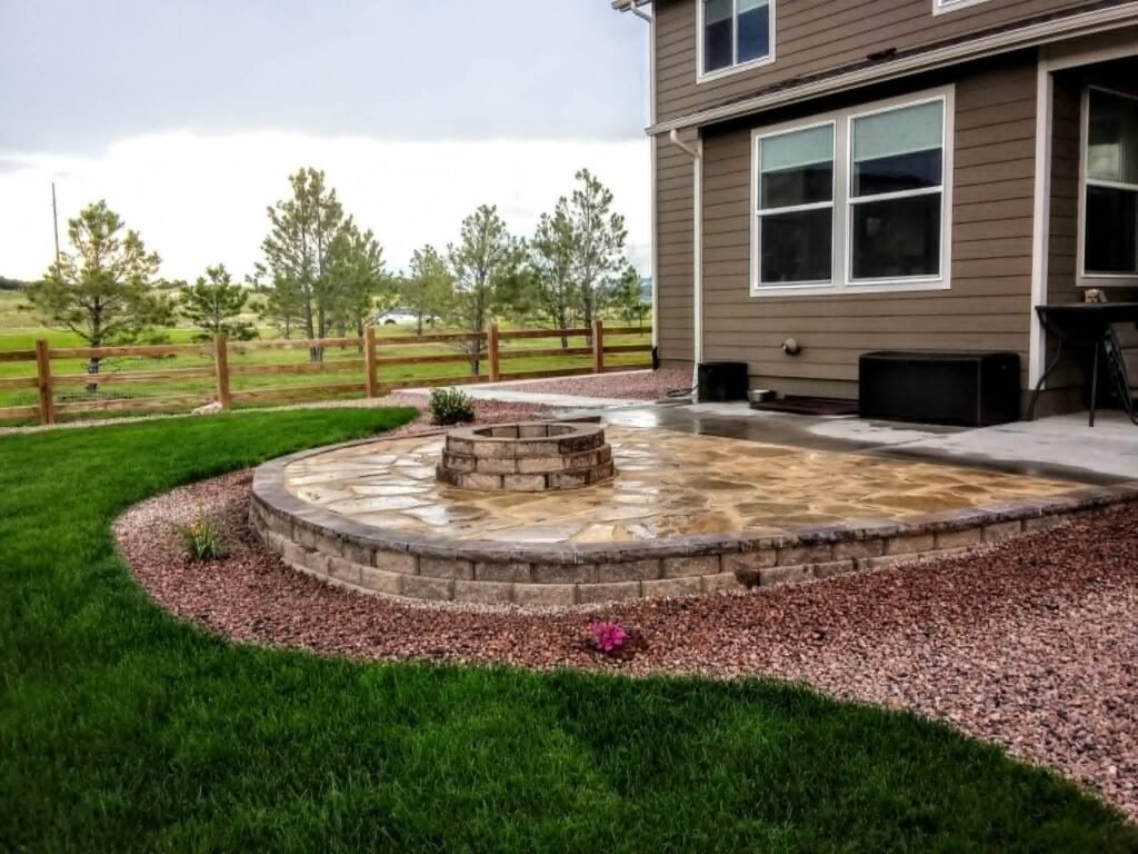 Tiered natural stone retaining wall creating level patio space

