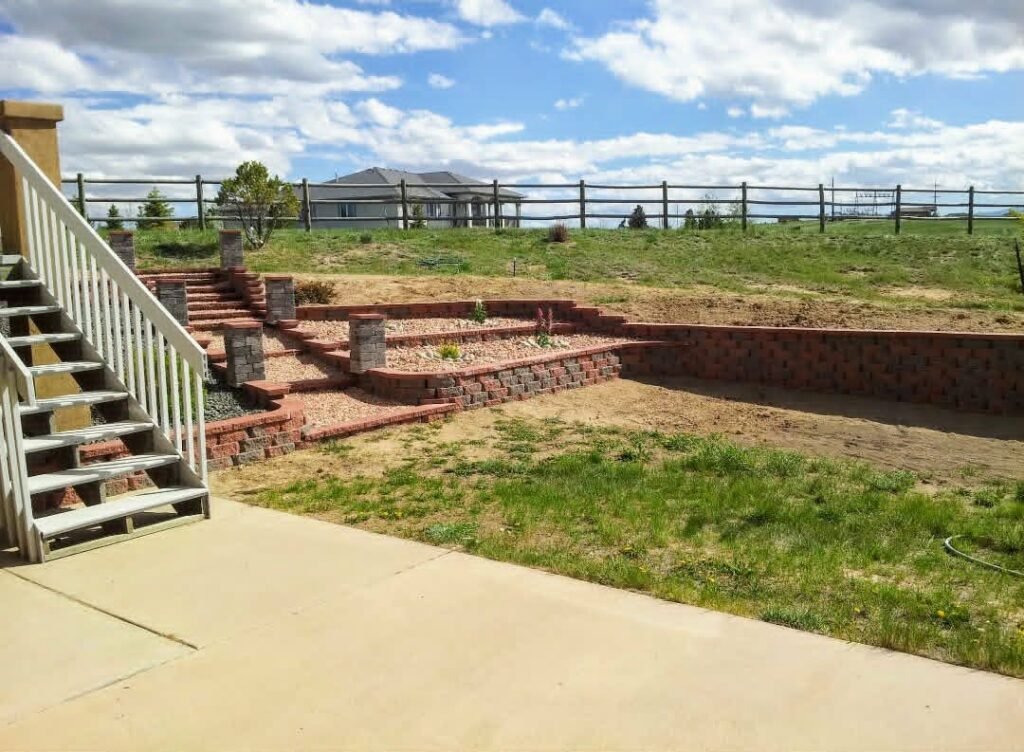 Concrete block retaining wall stabilizing a sloped backyard in Colorado Springs

