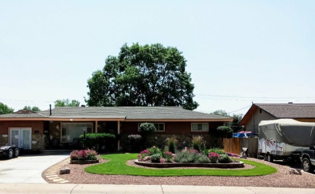 Front yard transformation from unfinished dirt to polished xeriscape with plants and rock

