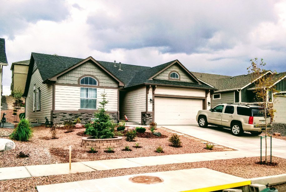 Front yard transformation from unfinished dirt to polished xeriscape with plants and rock

