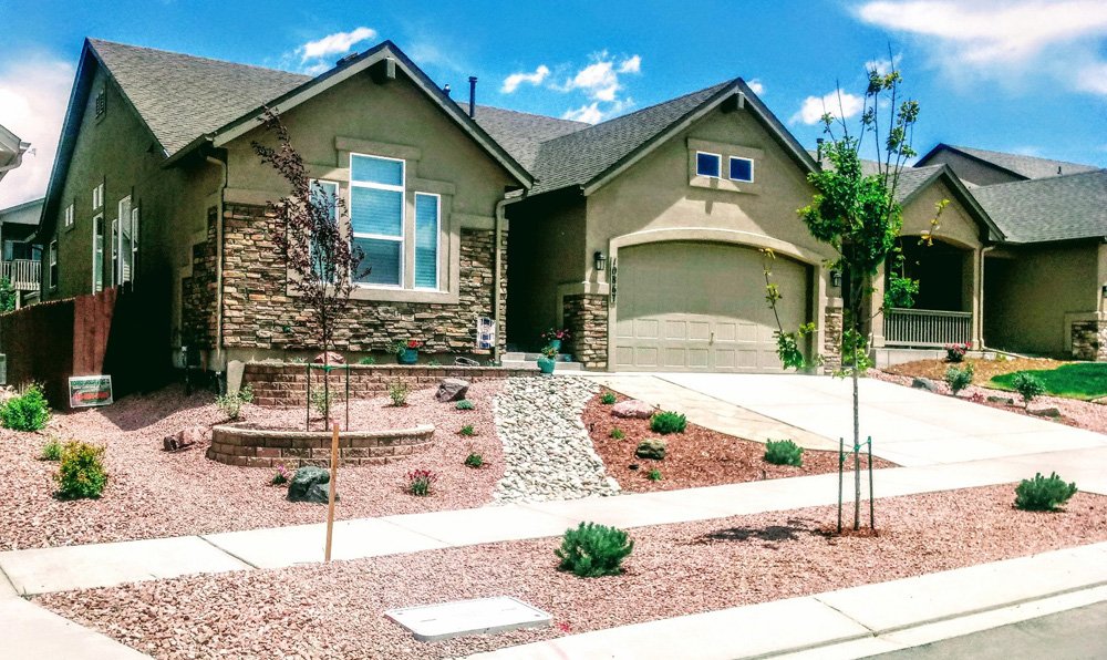 Front yard transformation from unfinished dirt to polished xeriscape with plants and rock

